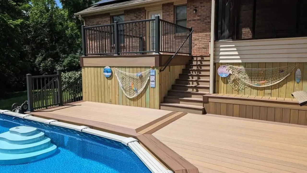 View of the pool deck with TimberTech Terrain composite decking, featuring dual staircases and black aluminum railing on the upper deck. The skirting is decorated with fishing nets.
