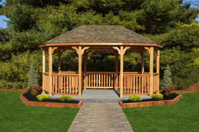 Custom gazebo in a backyard: wooden structure with asphalt shingle roof, paver walkway and landscaped raised beds